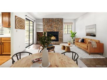 Inviting living room with stone fireplace, built-in shelves and sliding glass door to access the outdoors at 12560 E Warren Dr # E, Aurora, CO 80014