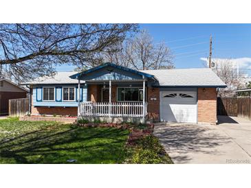 Charming single-Gathering home featuring a brick exterior, a cozy front porch with a white picket fence, and a well-manicured lawn at 921 S Wheeling St, Aurora, CO 80012