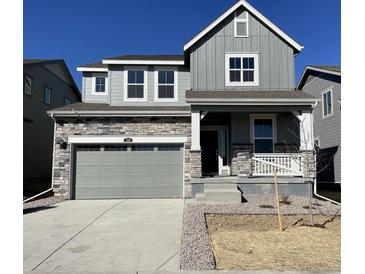 Charming two-story home featuring stone accents and a welcoming front porch, perfect for relaxing outdoors at 729 N Deer Park St, Watkins, CO 80137
