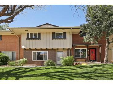Charming townhome with red brick and well-maintained front lawn and landscaped bushes at 12455 W Alameda Dr, Lakewood, CO 80228