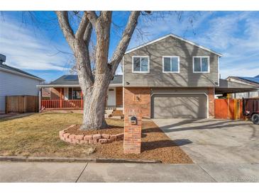 Two-story house with gray siding, attached garage, and landscaped yard at 2221 S Dearborn St, Aurora, CO 80014