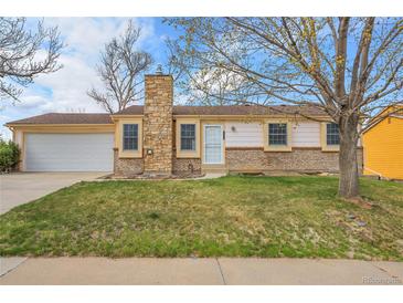 Charming single-story home with a stone chimney, well-manicured lawn, and a two-car garage at 11203 W Dorado Ave, Littleton, CO 80127