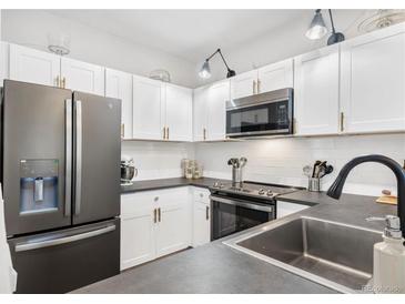 Modern kitchen featuring white cabinets, stainless steel appliances, and sleek countertops at 4085 S Crystal Cir # 101, Aurora, CO 80014