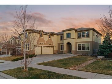 Two story stucco home featuring a spacious three car garage and well manicured front lawn at 26656 E Peakview Dr, Aurora, CO 80016