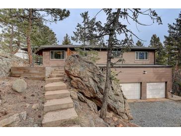 Charming exterior of a multi-level home with stone accents, stairs, and a two-car garage at 27857 Apex Cir, Evergreen, CO 80439