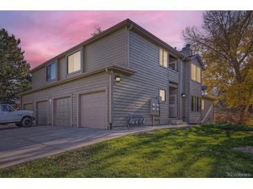 Two-story townhome with attached garage and landscaped lawn at 10212 W 80Th Dr # D, Arvada, CO 80005