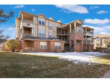 Multi-story condo building with brick accents, tan siding, private balconies and well-maintained lawn at 12762 Ironstone Way # 302, Parker, CO 80134