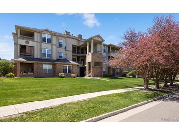 Lovely multi-story condo building with brick facade and well-manicured lawn at 12762 Ironstone Way # 302, Parker, CO 80134