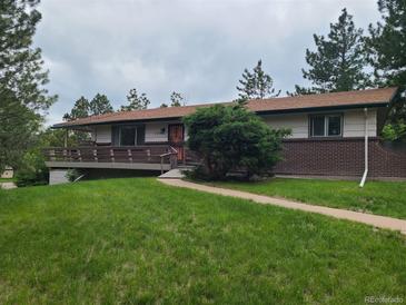 Charming single-story home with brick accents, lawn, and a welcoming front porch at 5274 W Rowland Pl, Littleton, CO 80128