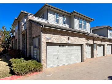 Exterior shows a two-story townhome with a brick facade and attached one-car garage with gray door at 6725 S Winnipeg Cir # 106, Aurora, CO 80016
