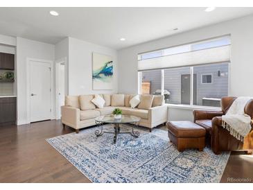Inviting living room featuring a comfortable sectional sofa, stylish rug, and plenty of natural light at 1568 Wolff St, Denver, CO 80204