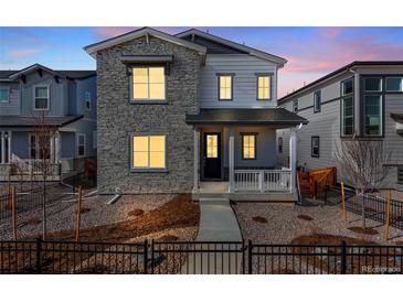 Charming two-story home with stone accents, a covered porch, and a well-maintained front yard at 3324 N Haleyville Ct, Aurora, CO 80019