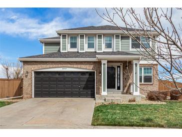 Inviting two-story home with brick and siding, featuring a two-car garage and well-maintained lawn at 24525 E Wagon Trail Ave, Aurora, CO 80016