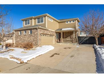 Two-story house with brick and siding, two-car garage, and covered porch at 3012 S Jericho Way, Aurora, CO 80013