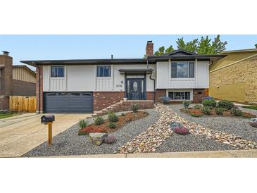 Inviting home exterior featuring manicured rock garden, modern front door, and attached garage at 2176 S Welch Cir, Lakewood, CO 80228