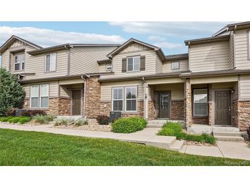 Charming townhouse exterior with stone accents and well-maintained landscaping on a sunny day at 17032 Blue Mist Grv, Monument, CO 80132