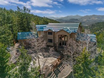 Gorgeous home with mountain views, lush trees, and a three car garage at 5699 Northwood Dr, Evergreen, CO 80439