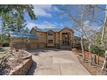 Stunning two-story home with a three-car garage and large driveway, ideal for mountain living at 5699 Northwood Dr, Evergreen, CO 80439