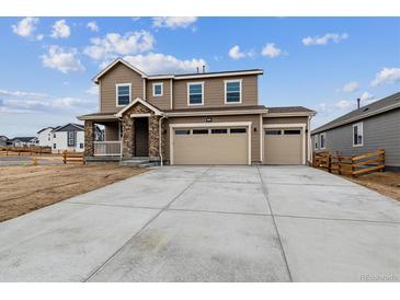 Two-story home with stone accents, three-car garage, and large concrete driveway at 574 Penn Rd, Elizabeth, CO 80107