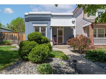Charming blue home with manicured front yard, lush green bushes, and rock landscaping at 2643 N Marion St, Denver, CO 80205