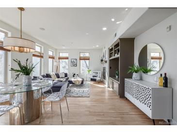Bright and open living room features large windows, fireplace, and hardwood floors at 1080 E 13Th Ave # 301, Denver, CO 80218