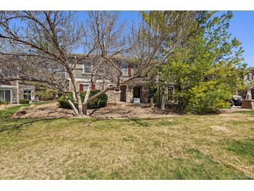 Charming townhome with stone accents, mature trees, and a well-manicured lawn at 9800 Mayfair St # E, Englewood, CO 80112