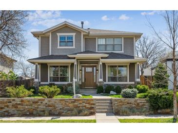 Charming two-story home with stone accents, lush landscaping, and inviting front porch, perfect for curb appeal at 1644 S Lafayette St, Denver, CO 80210