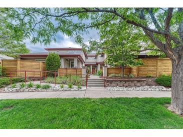 Inviting home exterior with landscaped front yard, mature trees, and charming architectural details at 980 S Locust St # D, Denver, CO 80224