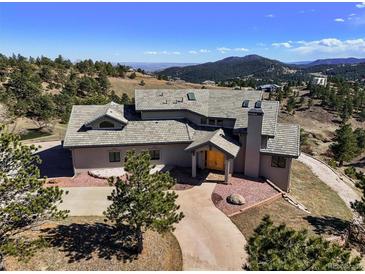 Stunning home featuring a stone driveway, mature trees, and a roof with multiple dormers and a stone chimney at 156 S Lookout Mountain Rd, Golden, CO 80401
