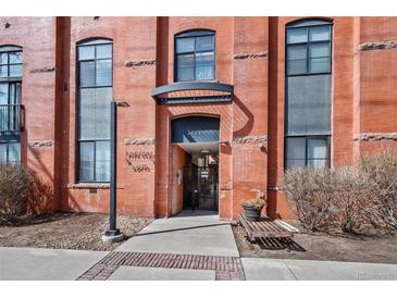 Exterior shot of building entrance featuring brick facade, gate, and well-manicured landscaping at 3225 Blake St # 8, Denver, CO 80205
