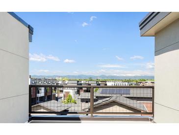 Balcony view overlooking rooftops with mountain views in the distance on a clear, sunny day at 22 Oneida Ct, Denver, CO 80230