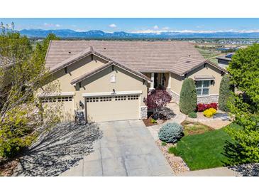 Beautiful home showcasing a three-car garage, mountain views, and a well-maintained lawn at 4965 Bierstadt Loop, Broomfield, CO 80023