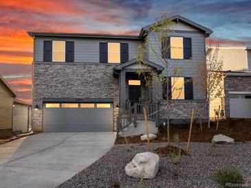 Beautiful two-story home with stone and gray siding, a well-manicured lawn, and a two-car garage at 1918 S Coolidge Way, Aurora, CO 80018