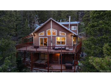 Charming cabin-style home with a large deck nestled in a lush, wooded setting at 302 Texas Dr, Idaho Springs, CO 80452