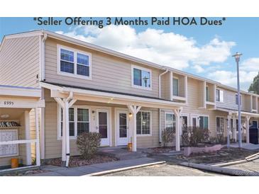 Charming condo with beige siding, covered entry, and well-maintained landscaping at 8975 Field St # 39, Broomfield, CO 80021