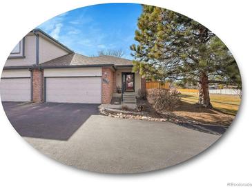 Charming townhome featuring a two-car garage, landscaped front yard, and inviting entryway at 6321 S Harrison Ct, Centennial, CO 80121