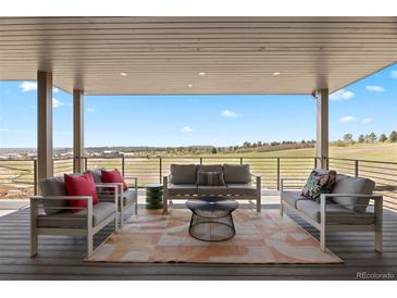 Inviting covered patio featuring comfortable seating and scenic views at 6176 Oxford Peak Ln, Castle Rock, CO 80108