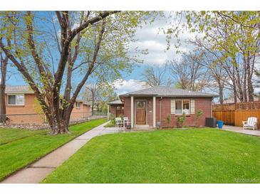 Charming brick home with a well-manicured lawn, mature trees, and a cozy front porch area at 2459 S Corona St, Denver, CO 80210