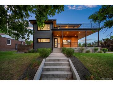 Modern two-story home with sleek gray siding, wood accents, and a second-story balcony at 1490 S Vine St, Denver, CO 80210