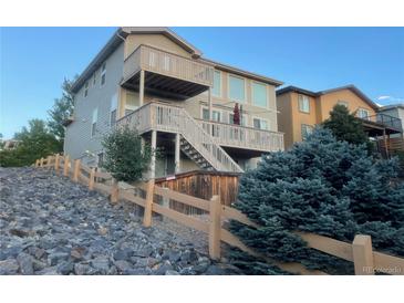 Multi-story home featuring multiple decks and wooden fence at 10475 Applebrook Cir, Highlands Ranch, CO 80130
