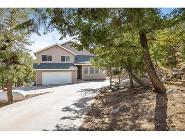 Charming two-story home with a well-maintained lawn and driveway, surrounded by lush trees at 2120 Gross Dam Rd, Golden, CO 80403