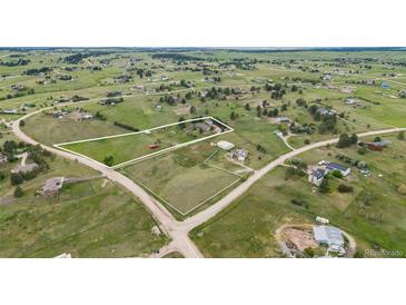 Expansive aerial view of a property surrounded by green fields and scattered houses in a rural community at 34586 Morgan Trl, Elizabeth, CO 80107