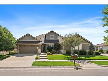 Charming single-Gathering home featuring a well-manicured lawn, stone accents, and an attached two-car garage at 22023 E Heritage Pkwy, Aurora, CO 80016