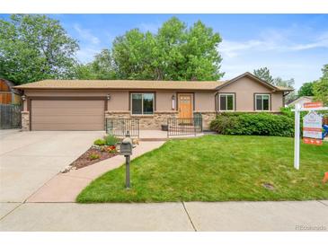 Charming single-Gathering home featuring well-manicured front yard and an attached two-car garage at 10563 Pierson Cir, Broomfield, CO 80021