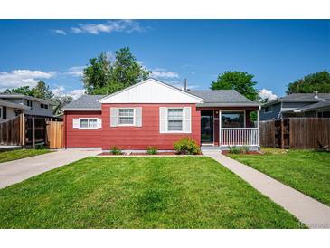 Charming red single-story home with a well-manicured front yard and white trim accents on a sunny day at 1955 Ingalls St, Lakewood, CO 80214