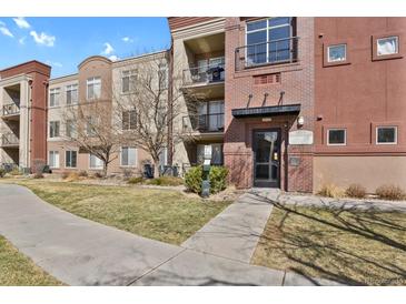 Modern condominium building with brick facade, balconies, and landscaped walkway at 14321 E Tennessee Ave # 1-301, Aurora, CO 80012