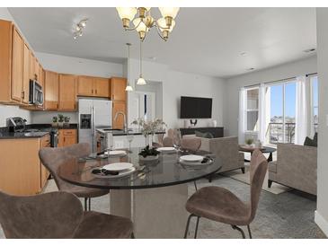 Bright, open-concept living space with modern finishes and a dining area connected to the kitchen at 14321 E Tennessee Ave # 1-301, Aurora, CO 80012