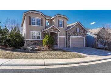 Beautiful two-story home featuring a stone and stucco facade, well-manicured lawn, and attached two-car garage at 10761 Hillsboro Cir, Parker, CO 80134