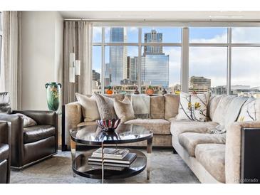 Bright living room featuring a comfortable sectional sofa and expansive city views through large windows at 1411 Wynkoop St # 806, Denver, CO 80202