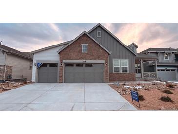 Charming home featuring a two-car garage, brick accents, and professionally landscaped front yard at 3856 Treadway Pt, Castle Rock, CO 80108